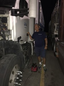 A man standing next to a truck in the dark.