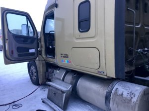A truck that has been broken down and is in the snow.