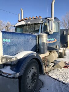 A large truck is parked in the snow.