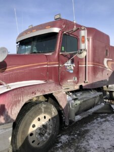 A man standing next to a red truck.