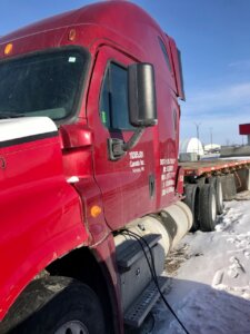 A red truck is parked on the side of the road.