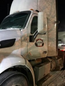 A white truck with the door open at night.