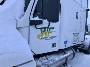 A white truck with snow on the side of it.