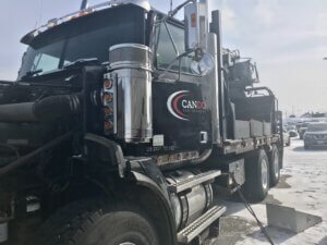A black truck parked on the side of a road.